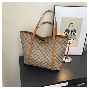 Large beige patterned tote bag with brown leather handles and gold fashion metal logo