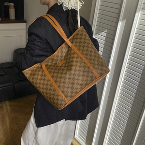 Classic retro monogram tote bag with brown leather handles and geometric pattern