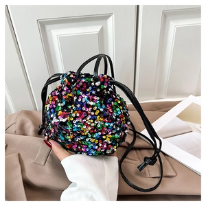 Gros plan des paillettes colorées et du cordon en cuir noir sur ce sac seau tendance