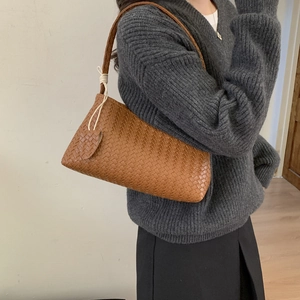 Détail du sac hobo tissé main couleur caramel avec motif tressé et breloque en cœur