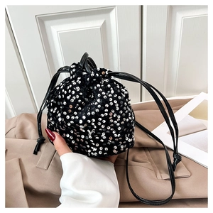 Détail du sac seau noir à paillettes argentées avec fermeture à cordon coulissant chic