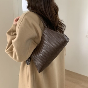 Détail de la texture en cuir tissé marron foncé d'un sac sous le bras élégant