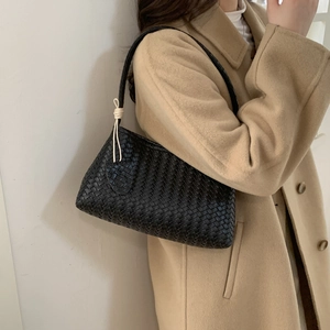 Vue détaillée du sac à bandoulière noir tissé main avec texture en cuir raffinée