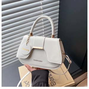 Dettaglio della borsa a sella in pelle PU bianca con finiture dorate e tracolla