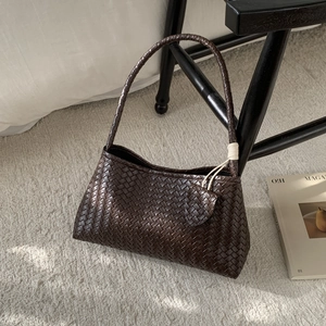 Detailed close-up of dark brown woven texture on a stylish underarm bag for women