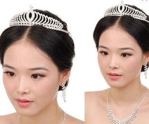 Close-up of bridal jewelry set with crystal tiara necklace and tassel earrings