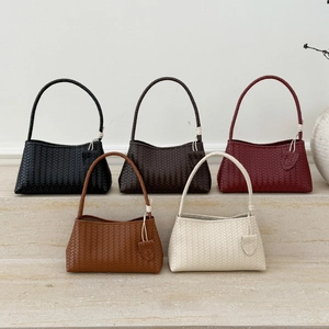 Macro detail of hand-woven texture on minimalist leather shoulder bags in five colors