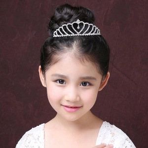 Detail of child wearing a silver heart-shaped crystal tiara for wedding or birthday party