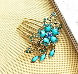 Détails d'un peigne à cheveux floral vintage avec strass bleus et pampilles de feuilles