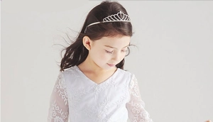 Detail of child wearing a silver rhinestone tiara with elegant heart design