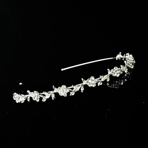Serre-tête floral argenté élégant avec strass brillants sur une surface noire élégante