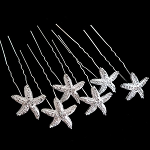 Macro shot of silver starfish U-shaped hair pins with sparkling rhinestones for bridal styling