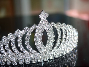 Close-up of sparkling silver tiara featuring heart-shaped cutouts and rhinestone details