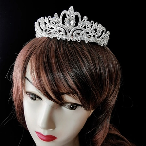 Close-up of bridal crown with silver filigree and heart-shaped rhinestone on a model
