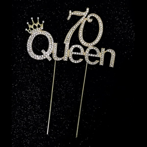 Détail de décoration de gâteau dorée strass 70 Queen avec couronne sur fond noir chic