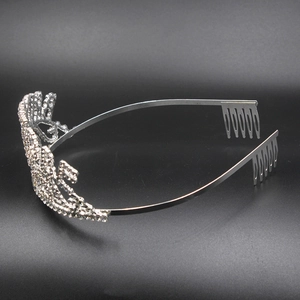 Detailed side view of a silver bridal tiara with sparkling rhinestones and securing combs