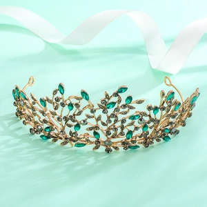 Detail of vintage gold bridal tiara with emerald crystals and branch leaf patterns