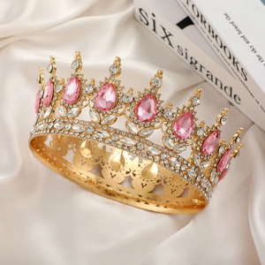 Macro shot of a luxury gold bridal crown with pink teardrop stones on white silk fabric