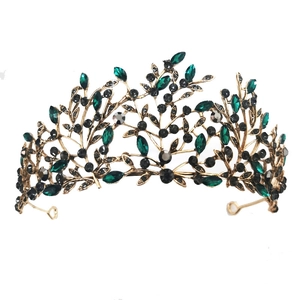 Detail of baroque bridal crown with emerald green stones and black crystals in gold frame
