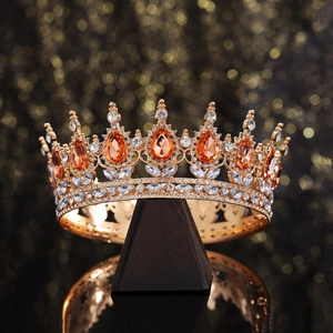 Luxury gold bridal crown with amber crystals and white diamonds on a dark display