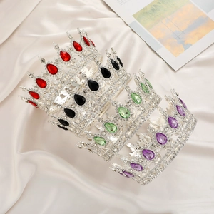 Detailed macro view of vintage rhinestone crowns in red, black, green and purple colors