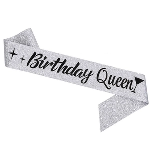Close-up of silver glitter Birthday Queen sash with black text and star details