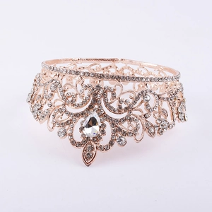Macro detail of rose gold bridal crown with pear-shaped center stone and crystal inlay