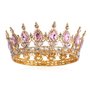 Macro detail of luxury golden crown with pink teardrop crystals and white zircon stones