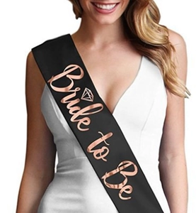 Macro detail of black satin Bride to Be sash with rose gold foil lettering for hen party