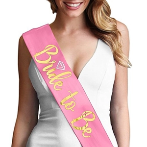 Detail of pink satin Bride to Be sash with gold lettering and diamond icon for parties