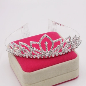 Elegante corona da sposa con strass argentati su un portagioie rosa per feste