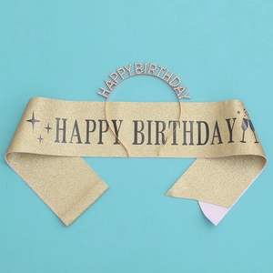 Détail du coffret anniversaire avec écharpe dorée pailletée et serre-tête en strass brillant