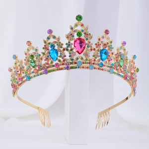 Baroque style golden tiara with colorful gemstones and side combs on a white stand