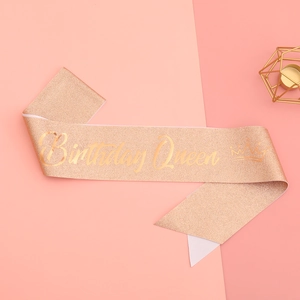Détail de l'écharpe d'anniversaire pailletée or rose avec lettrage doré élégant