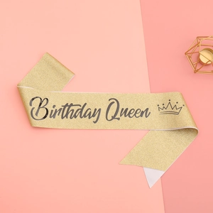 Détail de l'écharpe Birthday Queen à paillettes dorées avec texte noir et icône couronne