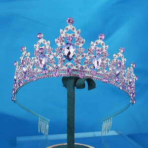 Detailed view of silver crown with purple rhinestones and large pear-cut center gemstone
