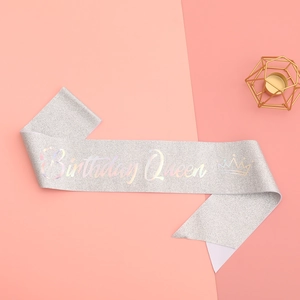 Détail de l'écharpe pailletée argentée avec texte Birthday Queen irisé et couronne