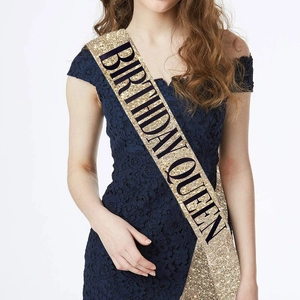 Close-up of a gold glitter birthday queen sash on a model for party celebrations