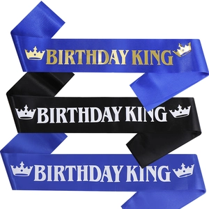 Detailed view of Birthday King sashes in blue and black with gold and white lettering