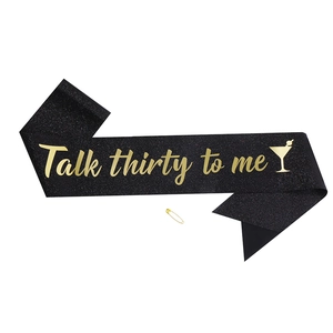 Detail of glittery black 30th birthday sash with Talk Thirty To Me gold text and pin