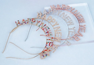 Détail de serre-têtes HAPPY NEW YEAR en strass brillants sur blocs acryliques