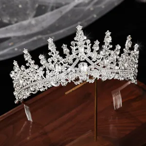 Detail of silver bridal crown with sparkling rhinestones on a wooden stand with lace