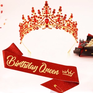 Detail of red glitter Birthday Queen sash and golden crystal crown with petals decor