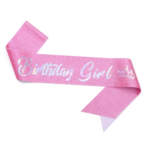 Close-up of glittery pink Birthday Girl sash with silver artistic lettering and crown