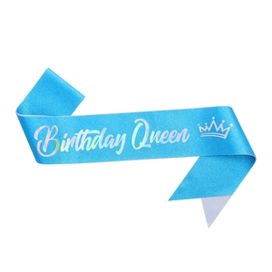 Close-up of sparkling blue glitter Birthday Queen sash with silver crown and art font