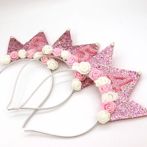 Close-up of pink glitter crowns with numbers 4, 5, and 6 featuring pearls and roses