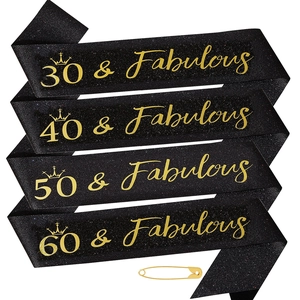 Detail of glitter black birthday sashes with gold foil text and safety pins for party