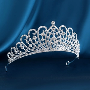 Sparkling rhinestone bridal crown with silver alloy scrollwork on navy silk background