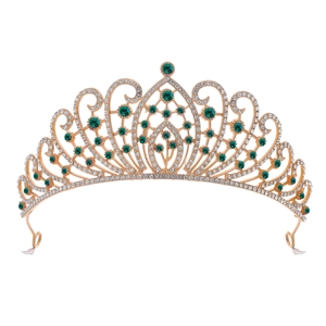 Macro view of gold alloy tiara featuring emerald green crystals and white rhinestones