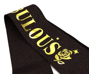 Détail de l'écharpe d'anniversaire noire pailletée avec motif rose et étoiles dorées